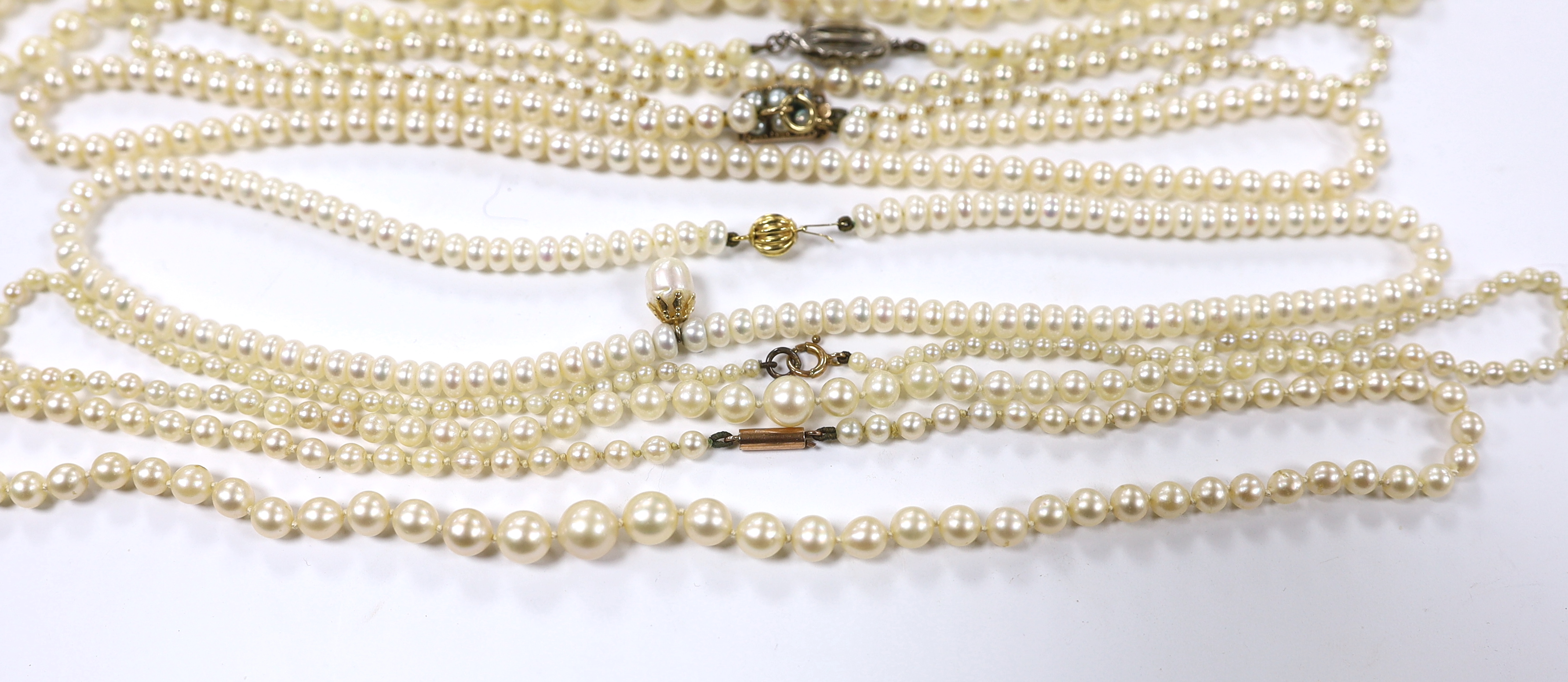 A collection of nine assorted cultured pearl necklaces with 9ct or yellow metal clasps.